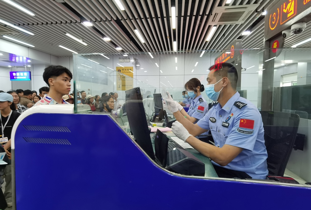 图为边检民警正在对入境旅客进行边防检查 林珉正摄