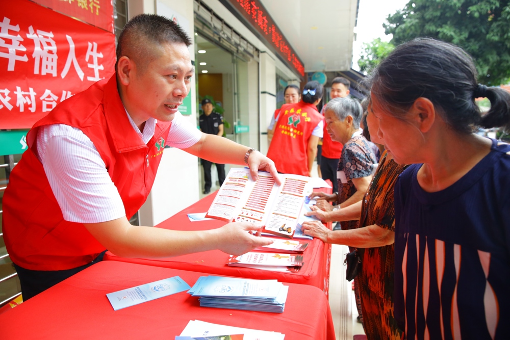 平乐农合行工作人员为群众宣讲知识手册