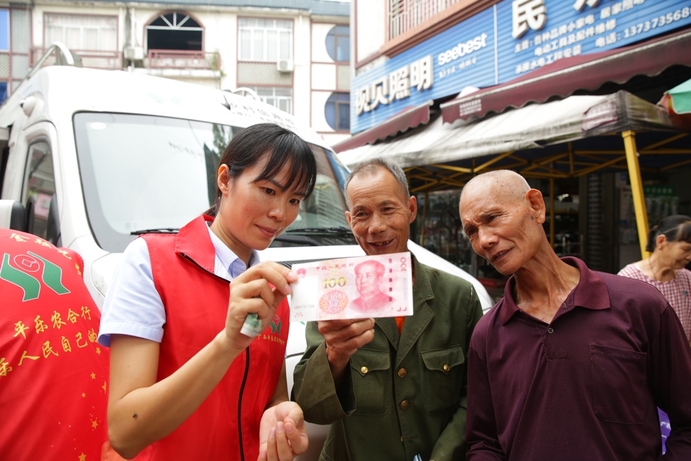 平乐农合行工作人员教群众识别人民币真伪1