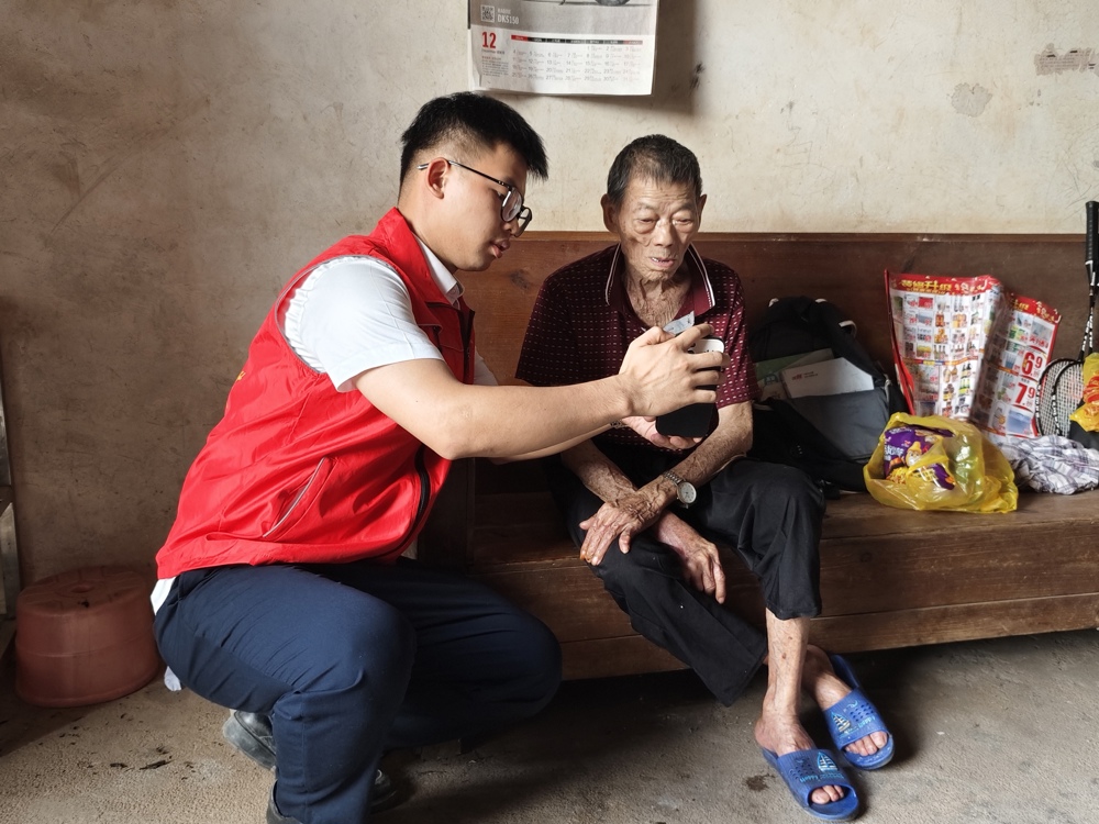 图为大坡信用社金融服务专员上门为高龄老人办理社保卡激活业务 大坡信用社供图