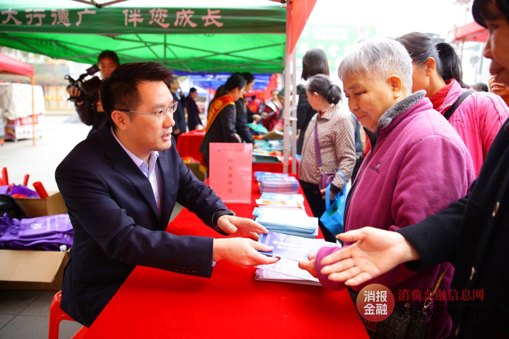 平乐农合行党委副书记、行长曹文科手持宣传折页为多位群众普及金融消费者八大权益