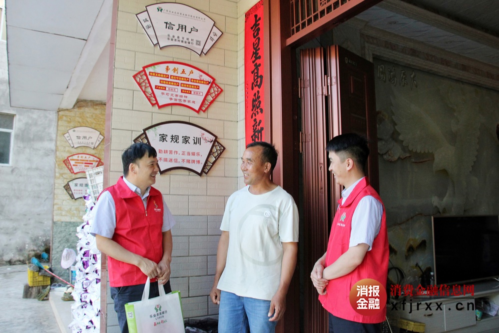 乐业农商银行新化支行工作人员向种植户班统茂了解其发展情况 黄圣凤摄